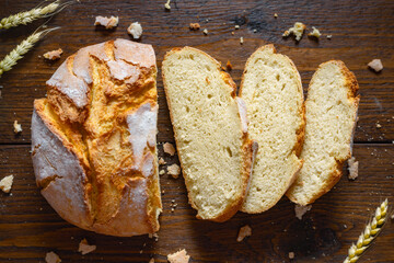 Aufkleber - Loaf of sliced bread with crumbs and ears of wheat on wooden table close up