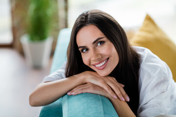 Poster - Portrait of gorgeous carefree glad person sitting comfy sofa hands under face beaming smile chilling apartment inside