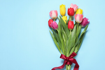 Wall Mural - Beautiful colorful tulips on light blue background, flat lay. Space for text
