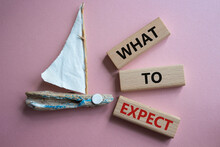 What To Expect Symbol. Concept Words What To Expect On Wooden Blocks. Beautiful Pink Background With Boat. Business And What To Expect Concept. Copy Space.