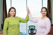 © PRASANNAPIX - Two indian women discussing and giving high five to each other at office