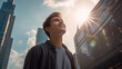 © Keitma - A happy young caucasian man looking up at the sky alone in a busy city, sun shining