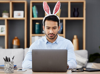 Poster - Laptop, bunny ears and business man for Easter in office with decoration for celebration, event and party. Corporate, focus and Asian male person on computer at desk with rabbit headband for holiday