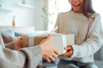 excited asian woman getting surprise gift from her girlfriend at home. gives a gift, birthday gift, 