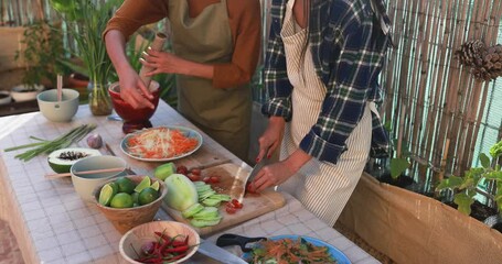 Wall Mural - Asian family preparing papaya salad with fresh spicy dressing at home patio outdoor - Adult sisters cooking dinner together  - Girl cutting tomatoes 