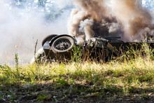 Historical Reconstruction. An Overturned And Dirty German Motorcycle Between Smoke And Dust After A Bomb Explosion..
