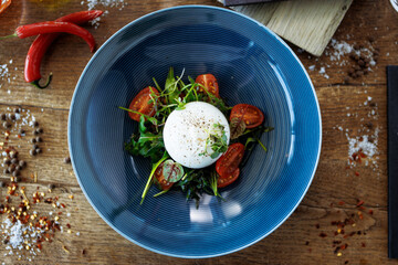 Wall Mural - Burrata with paprika-truffle jam and cherry-cluster tomato salad. Delicious healthy Italian traditional food closeup served for lunch in modern gourmet cuisine restaurant