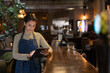 © ReeldealHD images - Waitress in a bar using a digital tablet for accounting