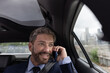 © ReeldealHD images - Businessman looking out of window in executive car on a phonecall