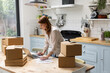 © ReeldealHD images - Female entrepreneur packing orders into cardboard boxes to ship