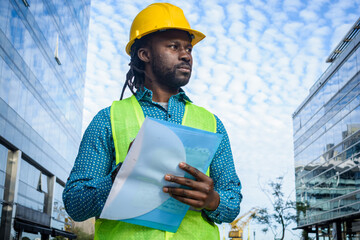 Wall Mural - portrait of black male architect standing outdoors thinking holding a folder