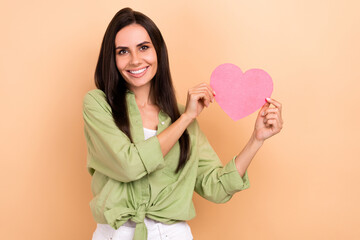 Sticker - Photo of optimistic stunning girl with straight hairstyle dressed green blouse fingers hold large heart isolated on beige color background