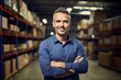 © Ai Studio - Smiling male supervisor in warehouse, arms crossed, looking at camera.