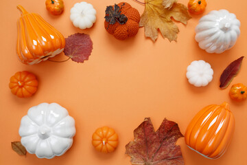 Wall Mural - Set of ceramic pumpkins and candles on orange background. Fall decor, interior decoration. Flat lay, top view, copy space