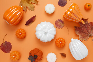 Wall Mural - Set of ceramic pumpkins and candles on orange background. Fall decor, interior decoration. Flat lay, top view, copy space