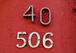 Numéros 40 - 506. Numéros de rue sur mur vieux rose.