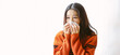 Panoramic banner image of sick Asian woman sitting windowsill with sneeze with tissue paper at home. Korean girl blowing nose, coughing in tissue at home, suffering from flu. Cold and fever concept