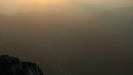 Wall Mural - Timelapse scene of sunset over rocky mountains with colorful sky in the evening