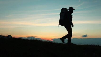 Sticker - Silhouette of man hiker walking against a sunset sky