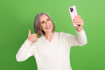 Sticker - Photo selfie cadre of funny grandmother wear white trendy pullover thumb up like sign recording video isolated on green color background