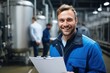© sirisakboakaew - Inside the food processing factory with a positive smiling technologist holding checklist Industrial workers are satisfied with the results and quality control.