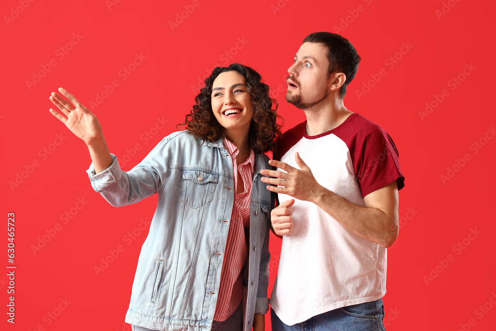 Happy young couple on red background