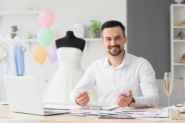 Canvas Print - Male wedding planner working with color palettes at table in office