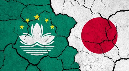 Flags of Macau and Japan on cracked surface - politics, relationship concept