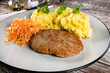 Minced meat cutlet served with mashed potatoes and carrot salad.