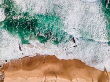 Aerial View Of Ocean Waves Crashing On Shore