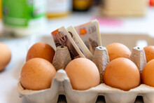 A Cost Of Living, Food Inflation Concept With Pound Sterling Bank Notes In A Packet Of Eggs.