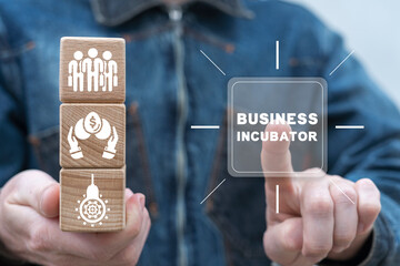 Man holding wooden cubes with icons clicks inscription on virtual screen: BUSINESS INCUBATOR. Concept of business incubator. Developing funding startup. Success investment. Business accelerator.