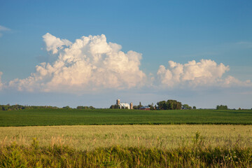 Wall Mural - Farm and fields under dramatic clouds on a sunny evening in Minnesota