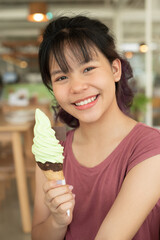 Wall Mural - Happy teen girl 11-15 year old. Beautiful young asian woman eating ice cream, Cheerful asian female portrait during summertime vacation, Leisure, people and lifestyle concepts, cafe.