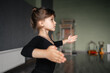 © troyanphoto - Child girl standing in black sport bodysuit in dancing studio during training posture. 4 5 years old preschool age. Healthy physical development