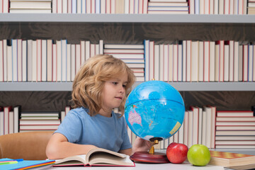 Aufkleber - School pupil looking at globe in library, geography lesson. School child studying in classroom at elementary school. Kid studying on lesson in class at elementary school.