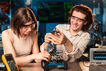 Wall Mural - Young man and woman doing experiments in robotics in a laboratory