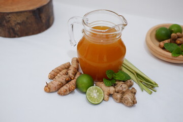 Ginger juice with fresh ginger and lemon on white background. Healthy drink.