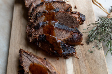 Wall Mural - Sliced ​​oven braised Beef brisket with gravy on a wooden cutting Board