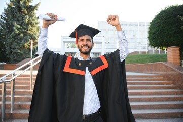 Wall Mural - portrait of successful indian student in graduation gown.