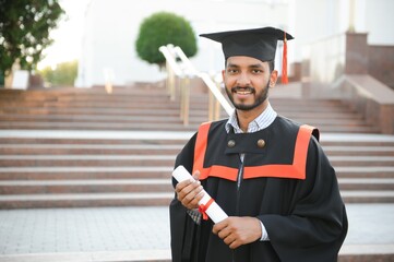 Poster - Portrait of indian handsome male graduate in graduation robe.