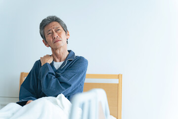 Poster - ベッドで起き上がって疲れに悩むシニア男性