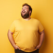 © PaulShlykov - Excited fat man celebrating success. Happy plus size bearded man on yellow background