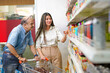 © Niks Ads - Happy Indian aged man purchasing in a grocery store with his young daughter.