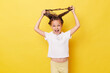 Crazy little girl with wet hair wearing casual white T-shirt standing isolated over yellow background tangled hair while washing screaming