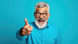 © Studio Nova - Senior man wearing casual clothes and glasses pointing with hand and finger to the side looking at the camera.