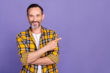 Sticker - Photo of positive man with white gray beard wear yellow plaid shirt indicating at offer empty space isolated on purple color background