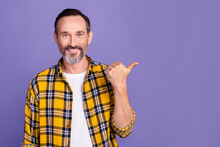 Photo Of Positive Man With White Gray Beard Wear Yellow Plaid Shirt Indicating At Sale Empty Space Isolated On Purple Color Background