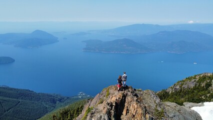 Sticker - two people standing on a large mountain on a clear day