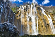 Majestic Waterfall Cascading Down A Rocky Mountainside, Plitvice National Park, Croatia